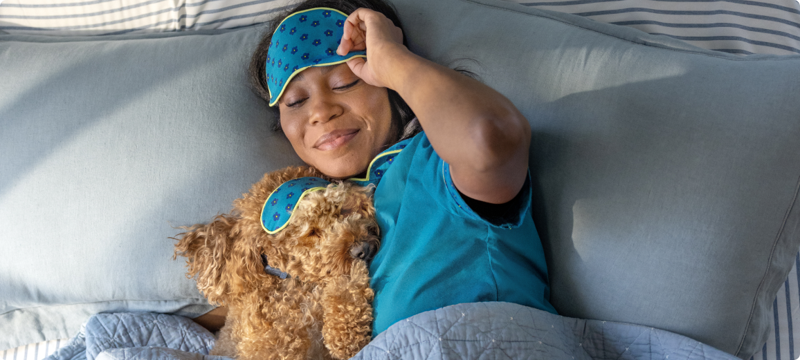 Câine odihnindu-se  în pat cu stăpânul său